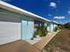 Lovely home featuring a blue exterior, white trim, an attached garage and well-maintained lawn at 4097 Rose Arbor Cir, Port Charlotte, FL 33948