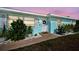 Charming entry with blue walls, white door, and decorative wreath in a well-maintained front yard at 4097 Rose Arbor Cir, Port Charlotte, FL 33948