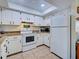 Traditional kitchen featuring white cabinets, granite countertops, a skylight, and modern appliances at 4097 Rose Arbor Cir, Port Charlotte, FL 33948