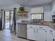 Updated kitchen with stainless steel dishwasher, granite countertops, and sliding glass doors at 4097 Rose Arbor Cir, Port Charlotte, FL 33948