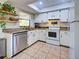 Bright kitchen features white cabinets, stainless steel appliances, and tile flooring at 4097 Rose Arbor Cir, Port Charlotte, FL 33948