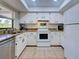 The kitchen has white appliances and cabinets, tile flooring, and granite countertops at 4097 Rose Arbor Cir, Port Charlotte, FL 33948