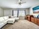 Carpeted living room featuring a white sectional sofa, and a ceiling fan at 4097 Rose Arbor Cir, Port Charlotte, FL 33948