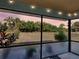 View from the screened patio to a fenced yard with mature landscaping at sunset at 4097 Rose Arbor Cir, Port Charlotte, FL 33948