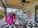 Screened patio view featuring a colorful playhouse and hanging swing chair at 4097 Rose Arbor Cir, Port Charlotte, FL 33948