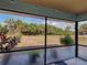 View from the screened patio to a fenced yard with mature landscaping at 4097 Rose Arbor Cir, Port Charlotte, FL 33948