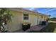 Home exterior featuring a convenient side door, trash bins, and air conditioning unit at 425 Belvedere Ct, Punta Gorda, FL 33950