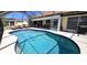 A screened in pool has an anchor design in the center and lounge seating nearby at 425 Belvedere Ct, Punta Gorda, FL 33950