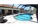 A beautiful in ground pool with steps and clear water surrounded by a screened in lanai with lounge furniture at 425 Belvedere Ct, Punta Gorda, FL 33950