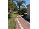 Landscaped backyard with a brick pathway leading through lush greenery and tropical palms at 4344 Commercial St, Port Charlotte, FL 33953