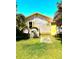 Exterior of a cozy home with yellow trim and tropical landscaping, nestled on a large lot at 4344 Commercial St, Port Charlotte, FL 33953