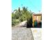 Side yard features a gravel driveway with lush plantings and exterior details of the home at 4344 Commercial St, Port Charlotte, FL 33953