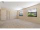A bright carpeted bedroom featuring two windows and convenient closet space at 453 Carolyn Ln, Punta Gorda, FL 33950
