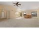 Spacious living room with carpet, ceiling fan, and large windows overlooking the backyard at 453 Carolyn Ln, Punta Gorda, FL 33950