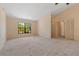 Spacious living room with neutral carpet, high ceilings, and a view of lush greenery through a large window at 453 Carolyn Ln, Punta Gorda, FL 33950