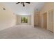Bright living room featuring neutral carpet, a ceiling fan, and a large window with a view at 453 Carolyn Ln, Punta Gorda, FL 33950