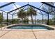 Inviting screened-in pool with serene waterfront views and swaying palm trees at 453 Carolyn Ln, Punta Gorda, FL 33950