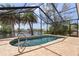 Screened-in pool overlooking a serene waterway with lush palm trees at 453 Carolyn Ln, Punta Gorda, FL 33950