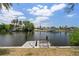 Serene waterfront view with wooden dock, mature landscaping, and peaceful surroundings at 453 Carolyn Ln, Punta Gorda, FL 33950