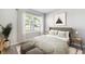 Comfortable bedroom with large window, neutral tones, patterned bedding, and matching side tables at 4960 Tuscola Blvd, North Port, FL 34287