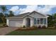 Charming single-story home featuring a two-car garage, manicured lawn, and inviting entryway at 4960 Tuscola Blvd, North Port, FL 34287