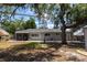 Backyard featuring a screened patio, mature trees providing shade, and a tranquil setting at 5333 Simrak St, North Port, FL 34287