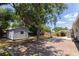 Backyard displaying the shed, mature trees, and plenty of space for outdoor activities at 5333 Simrak St, North Port, FL 34287