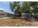 Large backyard with mature trees, a shed for storage, and ample green space at 5333 Simrak St, North Port, FL 34287