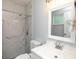 Bright bathroom featuring a white vanity, toilet, and a marble tiled shower at 5333 Simrak St, North Port, FL 34287