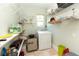 Functional laundry room featuring a washer, tiled floors, ample shelving, and bright natural light at 5333 Simrak St, North Port, FL 34287