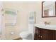 Bright bathroom with a toilet, dark wood cabinet vanity, and towel rack at 5520 Kenwood Dr, North Port, FL 34287