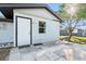 Back exterior with white trim, light, and an outdoor patio at 5520 Kenwood Dr, North Port, FL 34287