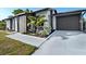 Inviting home entrance featuring fresh landscaping, a modern color scheme, and an attached one-car garage at 5520 Kenwood Dr, North Port, FL 34287