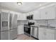 Updated kitchen with stainless steel appliances, granite countertops, and white cabinets at 5520 Kenwood Dr, North Port, FL 34287
