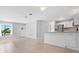 Open living space with hardwood floors connected to the kitchen with modern appliances and lots of natural light at 5520 Kenwood Dr, North Port, FL 34287