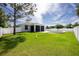The backyard is fenced with well-maintained grass, a pool, and a screened-in patio at 6245 Alhambra Ave, North Port, FL 34291