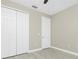 Bright bedroom features neutral walls, a ceiling fan, closet, and gray wood-look flooring at 6245 Alhambra Ave, North Port, FL 34291