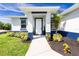 Inviting front entrance featuring manicured landscaping, a bright white door, and a covered porch at 6245 Alhambra Ave, North Port, FL 34291