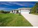 Well-maintained single-story home featuring a two-car garage, green lawn, and concrete driveway at 6245 Alhambra Ave, North Port, FL 34291