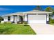 Charming single-story home with a two-car garage, freshly manicured lawn, and vibrant curb appeal at 6245 Alhambra Ave, North Port, FL 34291