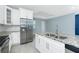 Bright kitchen featuring white cabinets, stainless steel appliances, and a granite-topped island at 6245 Alhambra Ave, North Port, FL 34291