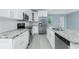 Updated kitchen with stainless steel appliances, granite countertops, and white cabinets at 6245 Alhambra Ave, North Port, FL 34291