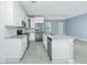 Open-concept kitchen boasts white cabinets, stainless steel appliances, and granite countertops at 6245 Alhambra Ave, North Port, FL 34291