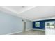 Open living area with recessed lighting, blue accent wall, and sleek light gray flooring at 6245 Alhambra Ave, North Port, FL 34291