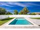 Backyard pool is fenced in with a white fence and has stone pavers and a green yard at 6245 Alhambra Ave, North Port, FL 34291