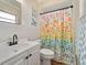 Charming bathroom featuring a white vanity, a sink, and a shower with a colorful, floral-patterned curtain at 6531 Marius Rd, North Port, FL 34287