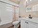 Neat bathroom featuring a white vanity, toilet, tub, and a shower with a marine-themed curtain for a fresh look at 6531 Marius Rd, North Port, FL 34287