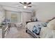 Cozy bedroom featuring a ceiling fan, natural light, a hanging chair, and comfortable sleeping arrangements at 6531 Marius Rd, North Port, FL 34287