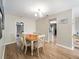 Bright dining area features wood floors, a modern light fixture, and a classic wooden table with seating for six at 6531 Marius Rd, North Port, FL 34287