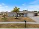 Well-maintained single-Gathering home featuring a light blue front door, garage and mature palm tree at 6531 Marius Rd, North Port, FL 34287